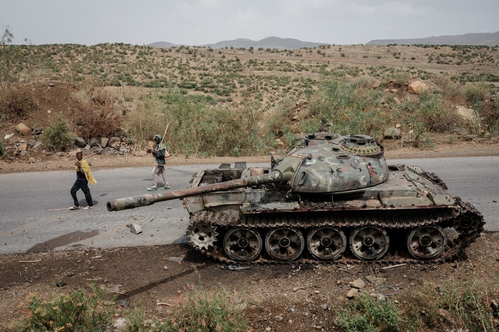 Local farmers walk next to a damaged tank that is abandoned along the road in Dansa, southwest of Mekele in Tigray region, Ethiopia June 20, 2021. u00e2u20acu201d AFP pic