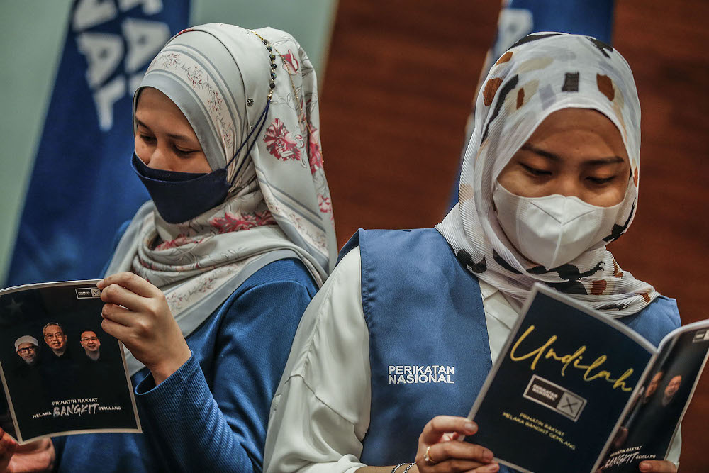 Perikatan Nasional Srikandi members read a Perikatan Nasional manifesto book during the launch at the Glenmarie Hotel and Resort November 14, 2021. ― Picture by Hari Anggara