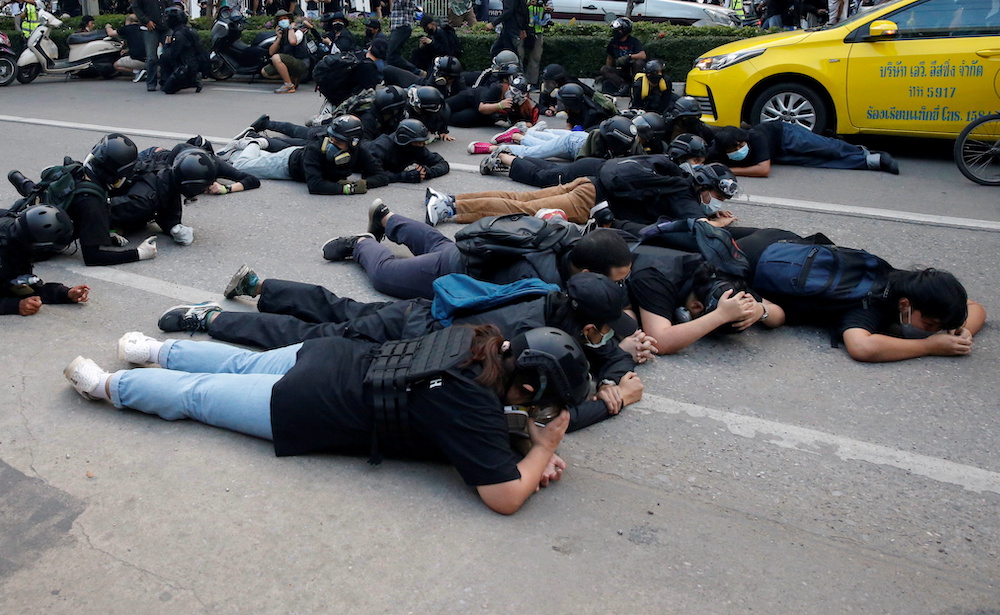 Demonstrators take cover from rubber bullets during a clash with the police while protesting against the amendment of the lese majeste law, in Bangkok, Thailand November 14, 2021. u00e2u20acu201d Reuters picnn