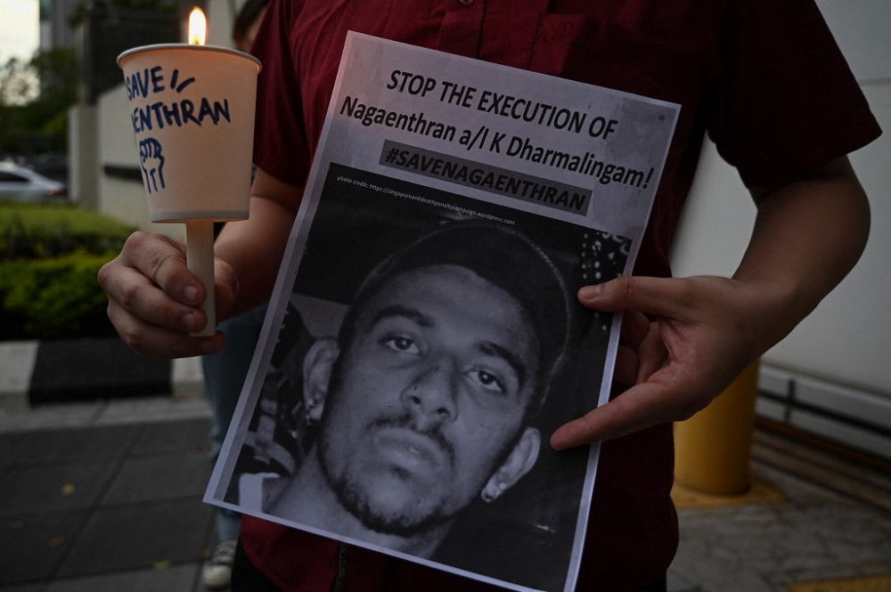 An activist holding a placard attends a candlelight vigil against the impending execution of Nagaenthran K. Dharmalingam, outside the Singaporean embassy in Kuala Lumpur on November 8, 2021. u00e2u20acu201d AFP pic