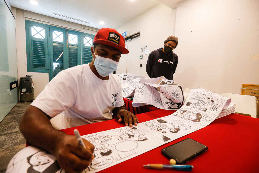 Local cartoonist Azmi Hussin is seen in his attempt to draw the longest comic strip in the country during the 3 X 3 Group Exhibition in conjunction with the Georgetown Festival in Penang November 26, 2021. — Picture by Sayuti Zainudin