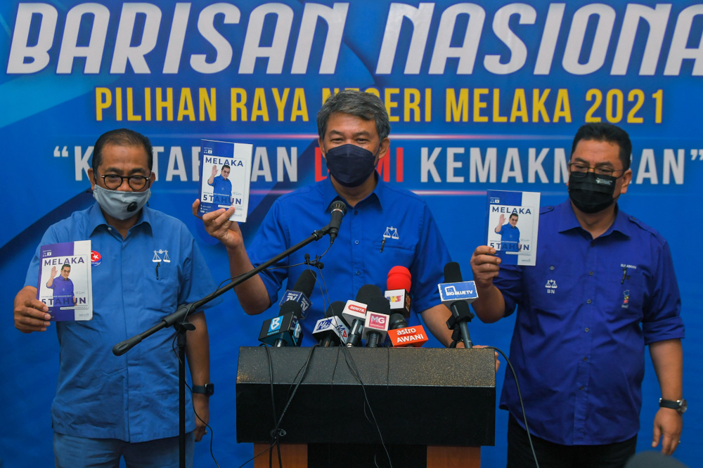 BN deputy chairman Datuk Seri Mohamad Hasan with Datuk Seri Sulaiman Md Ali, BN candidate for the Lendu state constituency, and Umno vice-president Datuk Seri Mohamed Khaled Nordin with the BN manifesto, Melaka, November 10, 2021. u00e2u20acu201d Bernama pic 
