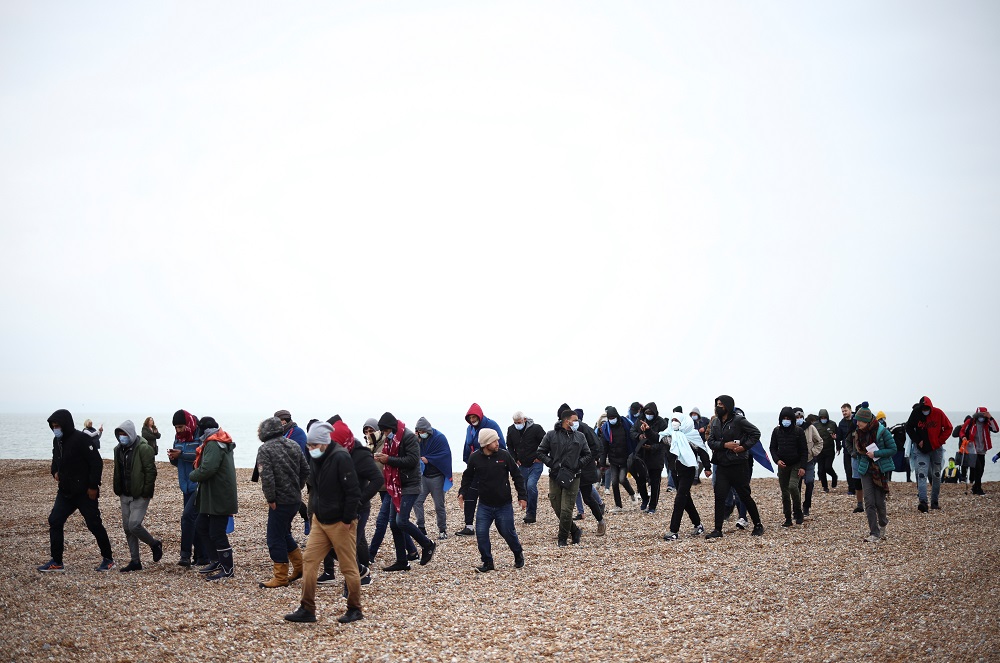 Migrants walk along a beach after being brought ashore by a RNLI Lifeboat, after having crossed the channel, in Dungeness, Britain November 24, 2021. u00e2u20acu2022 Reuters pic