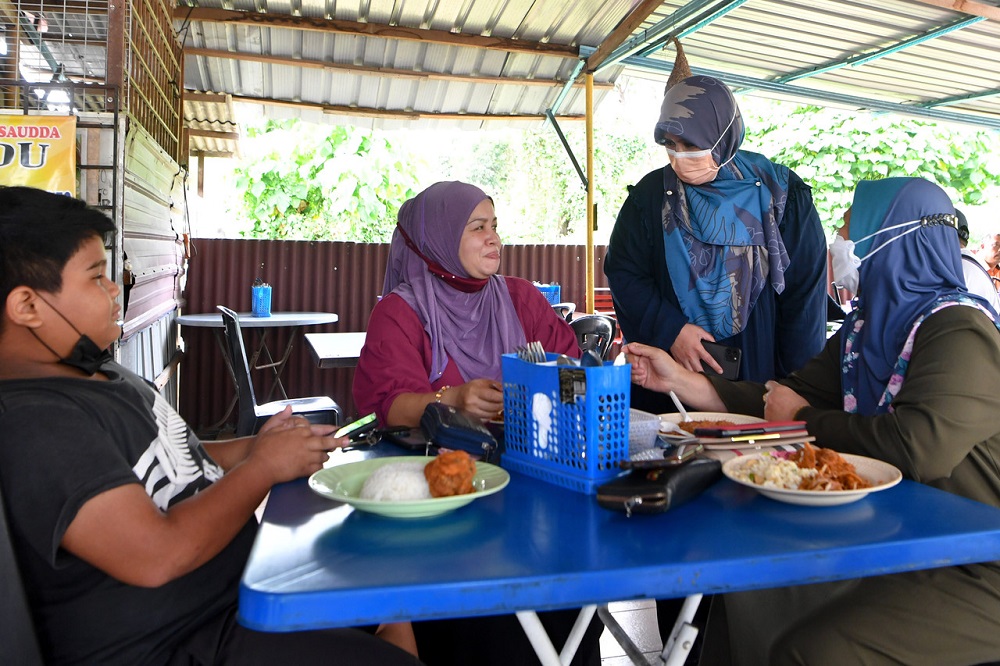 Perikatan Nasionalu00e2u20acu2122s Tanjung Bidara candidate Datuk Mas Ermieyati Samsudin (second from right) chats with members of the public at an eatery in Alor Gajah, Melaka November 10, 2021. u00e2u20acu201d Bernama pic 