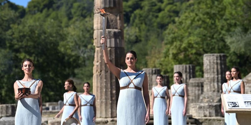 Greek actress Xanthi Georgiou (centre), playing the role of the High Priestess, holds up the lit torch during the flame lighting ceremony for the Beijing 2022 Winter Olympics at the Ancient Olympia archeological site. u00e2u20acu2022 ETX Studio pic