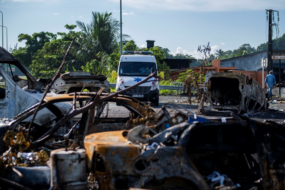 An ambulance manoeuvres around burned cars and debris barricade on a round-about on highway N1 after violent demonstrations which broke out over Covid-19 protocols, in Petit-Bourg, Guadeloupe November 23, 2021. u00e2u20acu2022 Reuters pic