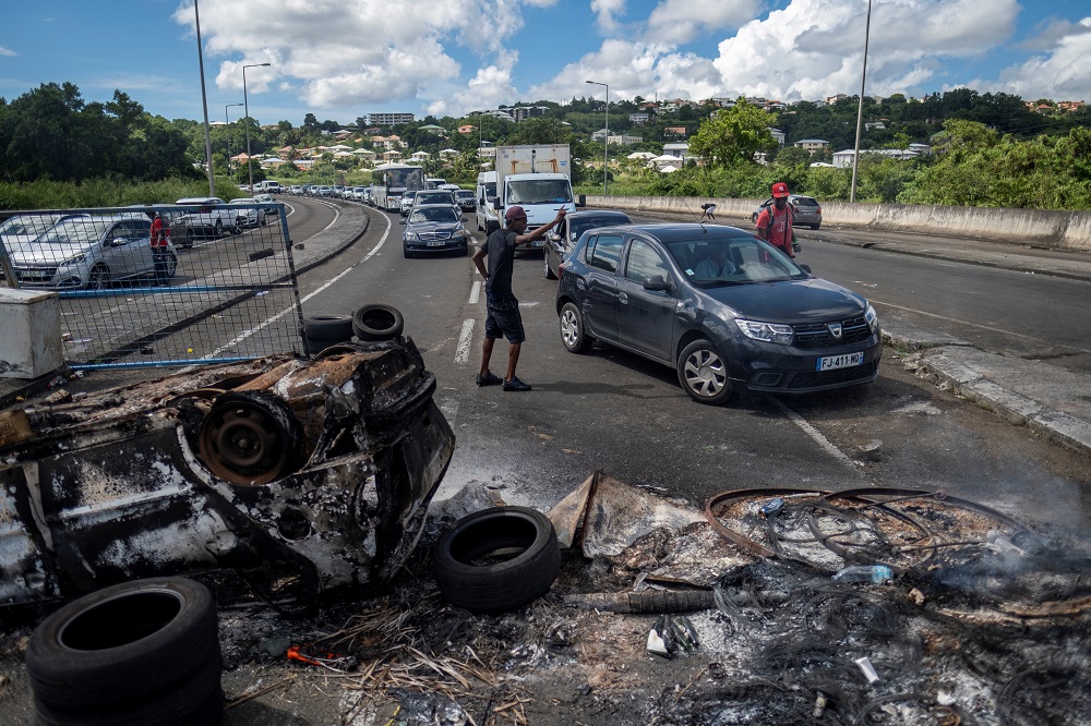 People divert traffic at a barricade blocking the road leading to the airport after unrest triggered by Covid-19 curbs, which have already rocked the nearby island of Guadeloupe, in Fort-De-France, Martinique November 24, 2021. u00e2u20acu2022 Reuters pic