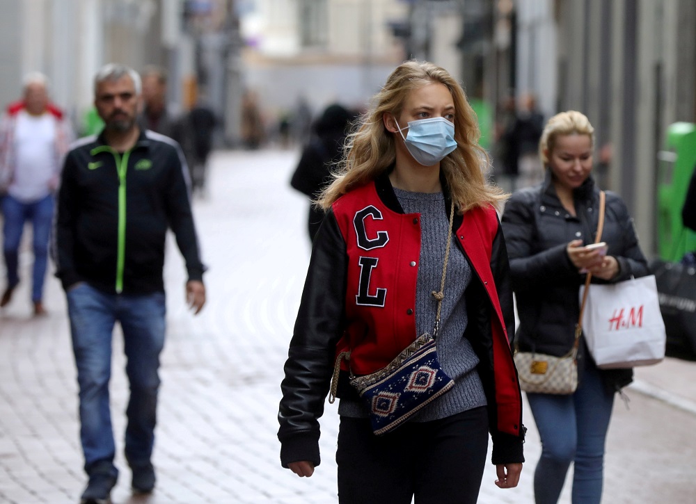People with and without protective masks walk on the street while shopping in Amsterdam, Netherlands October 7, 2020. u00e2u20acu2022 Reuters file pic