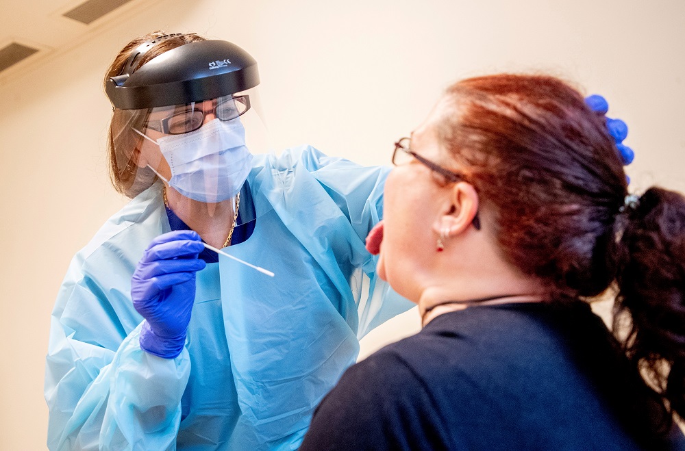 A nurse takes a sample from a nursing aide for a rapid Covid-19 test before she can start her shift at a home for elderly in Lerum, Sweden December 18, 2020. u00e2u20acu2022 TT News Agency/Adam Ihse via Reuters