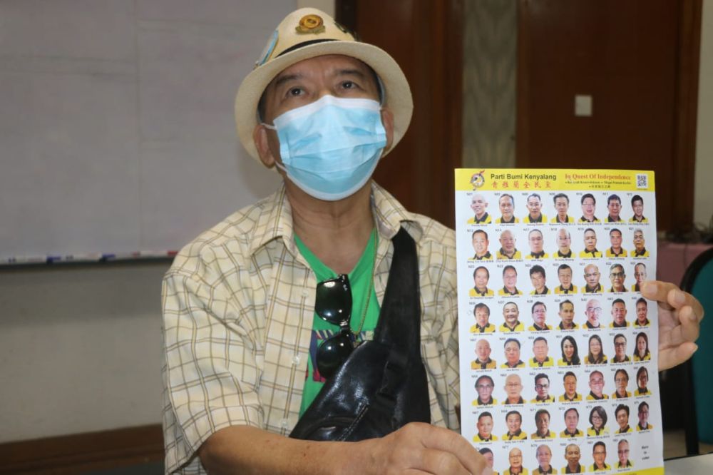 Ignatius shows the PBK poster that still features the names and photos of former members, including himself. u00e2u20acu201d Picture via Borneo Postnn