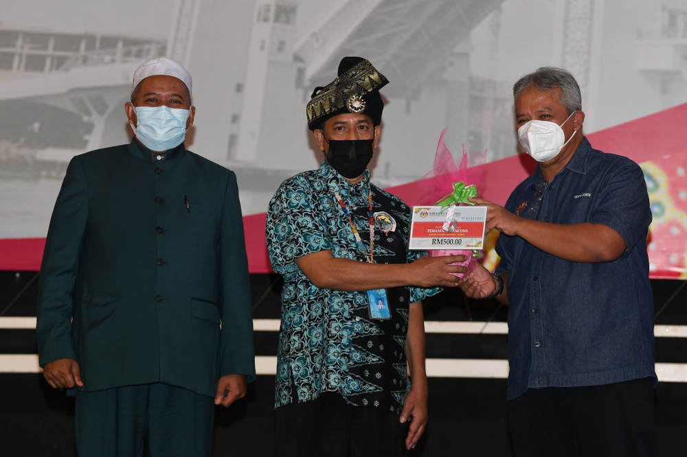 Motac secretary-general Datuk Noor Zari Hamat presenting financial aid to tour guide Nazarulzaman Kamarul Zaman in Terengganu, November 3, 2021. u00e2u20acu201d Bernama picnn