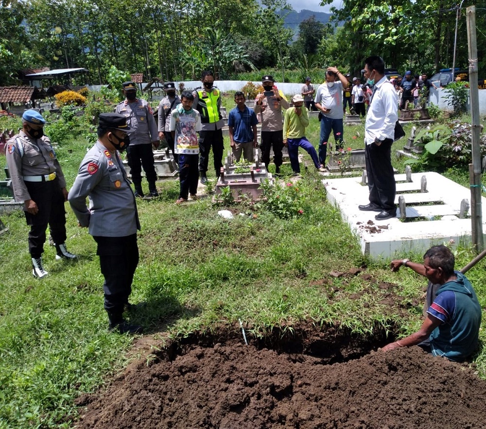Robyek (sitting down) with a crowd watching him after he had dug up his wife's grave. u00e2u20acu2022 Picture via Facebook/PonorogoUp