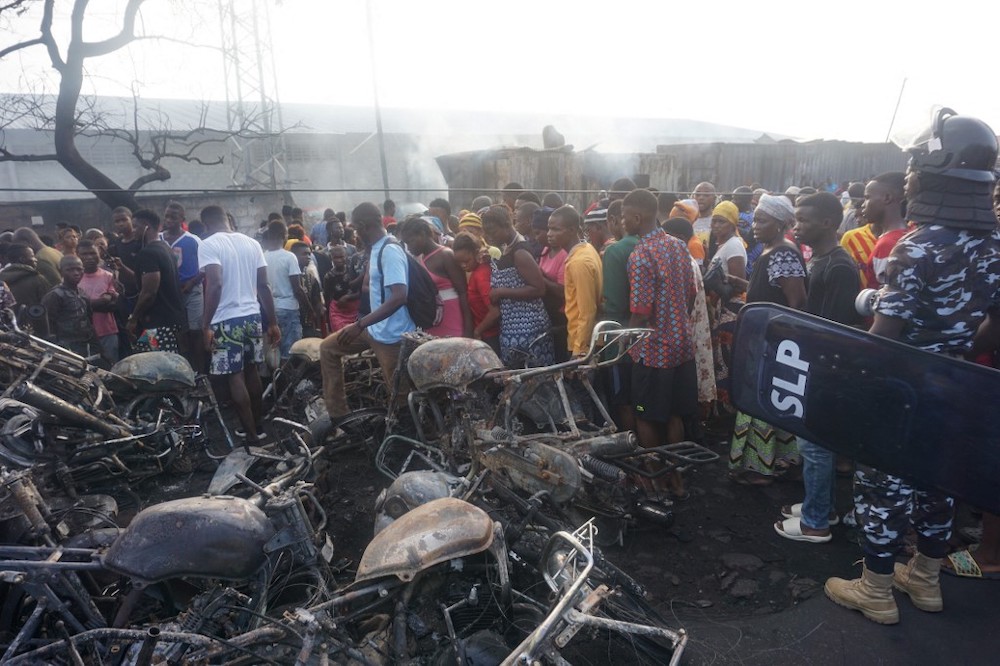People look on at a pile of burnt motorbikes in the aftermath of a fuel tanker explosion in Freetown on November 6, 2021. u00e2u20acu201d AFP picnn