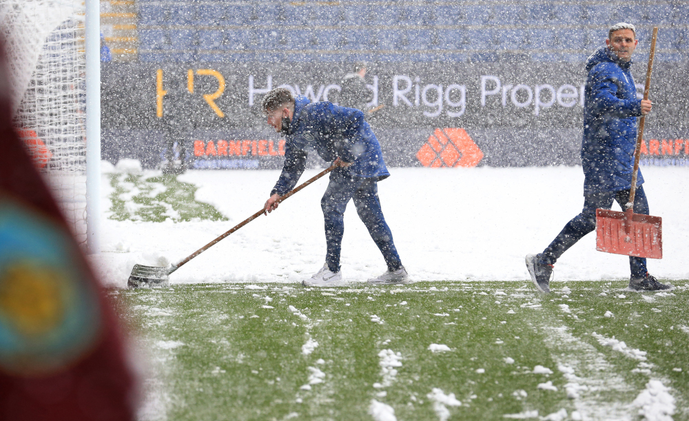 Ground staff work to clear snow from the pitch ahead of the English Premier League football match between Burnley and Tottenham Hotspur at Turf Moor in Burnley, north-west England, November 28, 2021. u00e2u20acu201d AFP pic