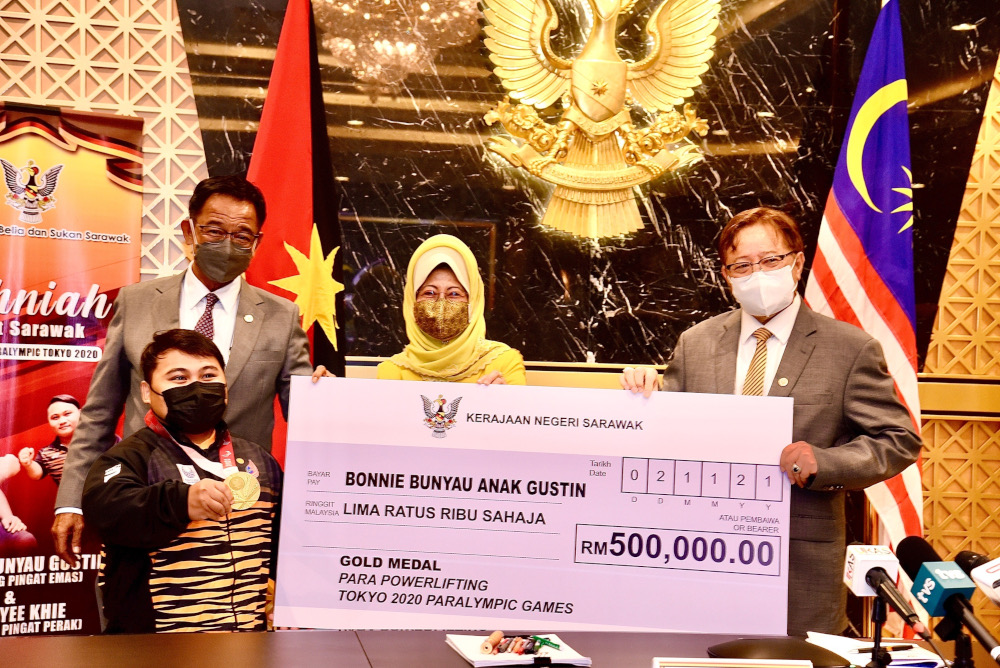 Chief Minister Datuk Patinggi Abang Johari Openg presenting a mock cheque for RM500,000 to Bonnie Bunyau Gustin (left), November 2,2021. u00e2u20acu201d Picture by State Information Departmentnn