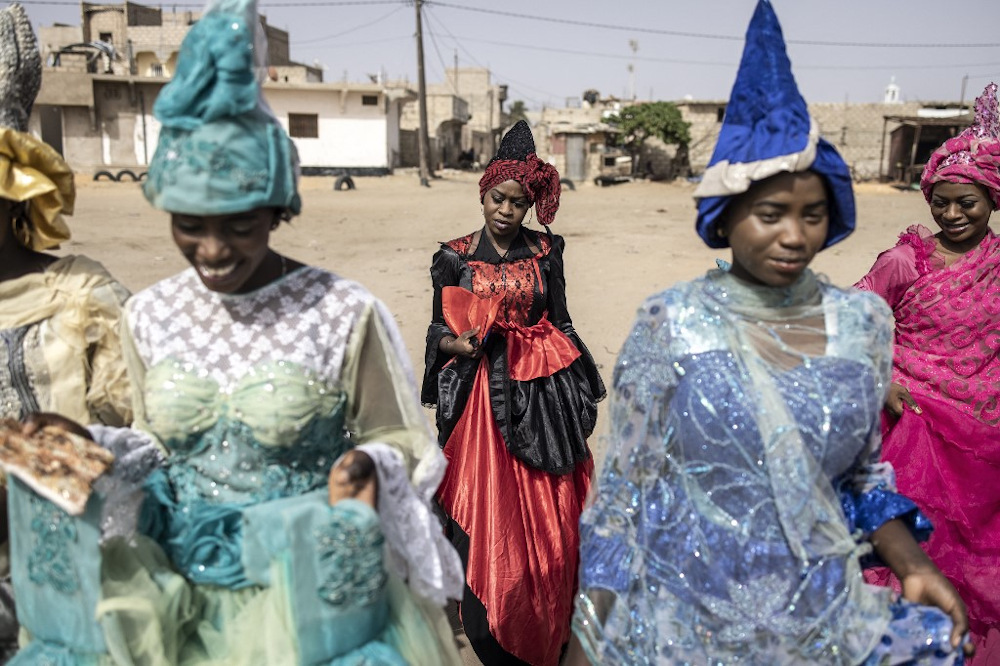Models working with fashion designer, Ndeye Diop Guisse, walk whilst wearing their traditional Signares outfits through the outskirts of Saint Louis on August 10, 2021. u00e2u20acu201d AFP pic