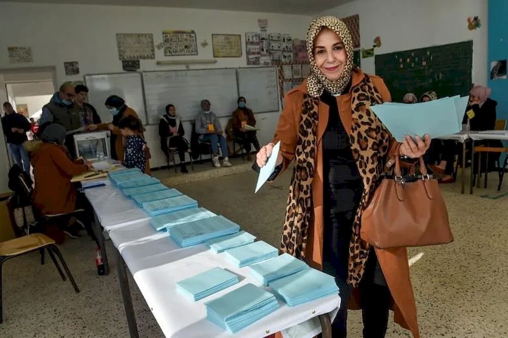 A woman picks up a ballot to vote in Algerian local elections on November 27, 2021. u00e2u20acu201d AFP pic
