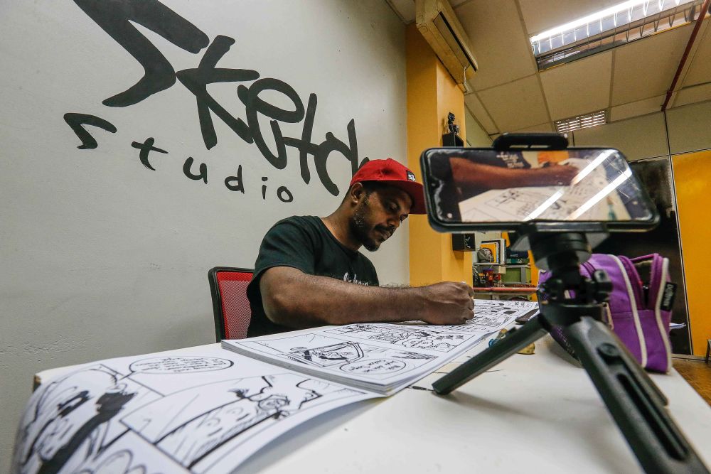 Penang cartoonist Mohd Azmi Mohd Hussin puts the finishing touches to his 150-metre comic strip for an upcoming exhibition at the Me Sketch Studio in Air Itam November 8, 2021. u00e2u20acu201d Picture by Sayuti Zainudin