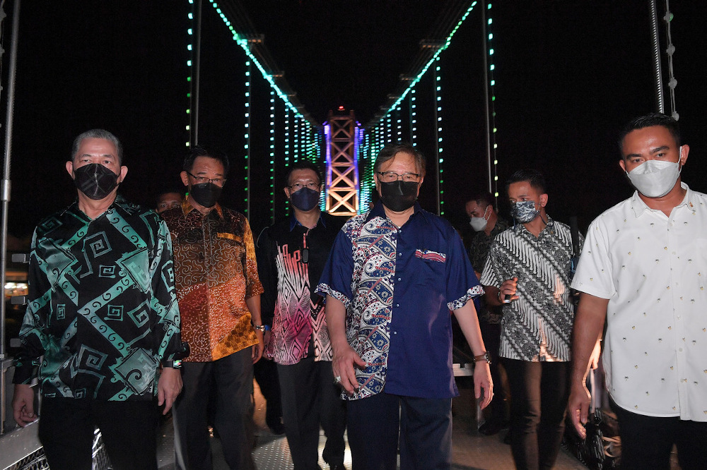 Sarawak Chief Minister Tan Sri Abang Johari Openg (centre) walks on the Satok Suspension Bridge during its opening ceremony in Kuching November 21, 2021. u00e2u20acu201d Bernama pic 