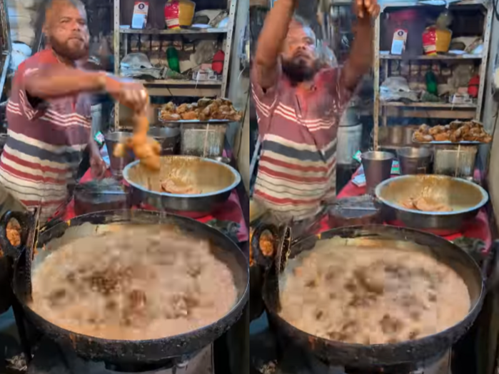 An Indian hawker dipping his hands into boiling hot oil to fry chicken in a video now circulating on social media. u00e2u20acu201d Screenshot via Instagram/nonvegfoodie