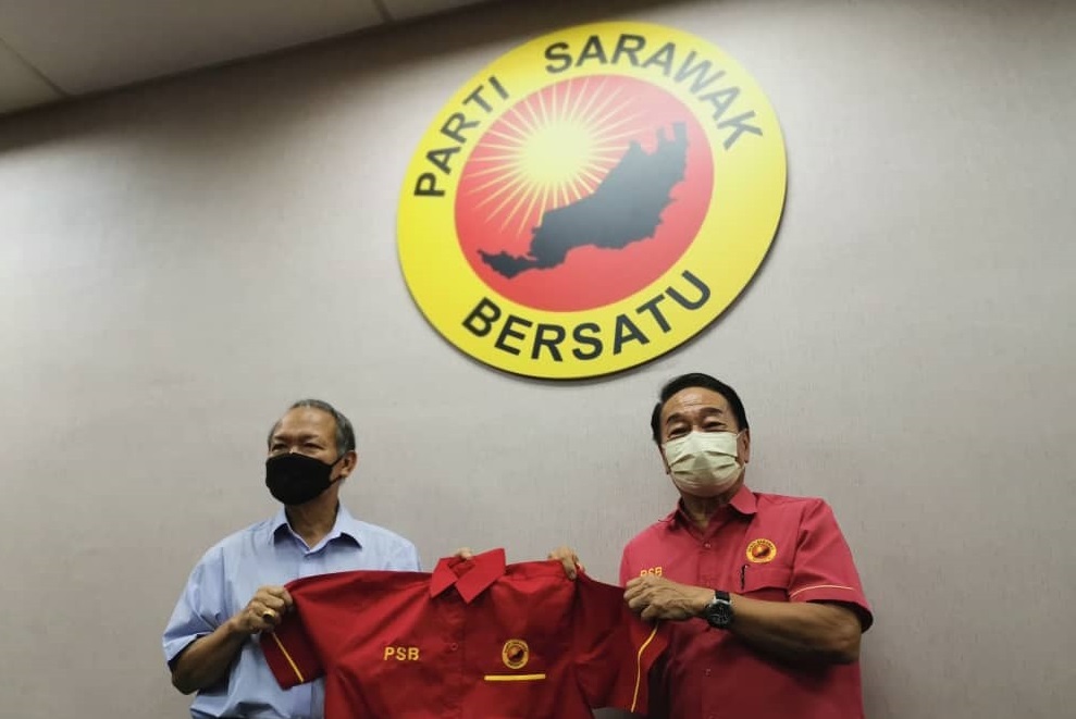 Wong hands Bolly (left) a PSB shirt. u00e2u20acu201d Picture via Borneo Post