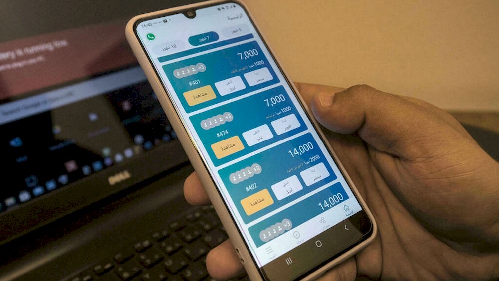 An employee of u00e2u20acu02dcAl-Gameyau00e2u20acu2122, a tech startup for money-pooling, holds a phone with the application at the company offices in Egyptu00e2u20acu2122s capital Cairo. u00e2u20acu201d AFP pic