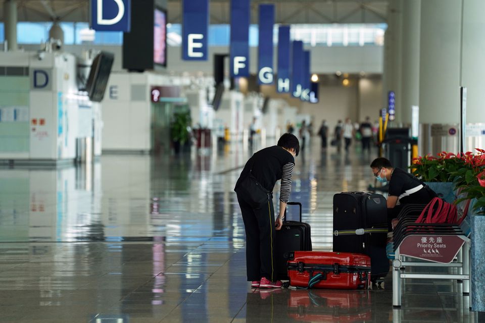 A woman, wearing a face mask following the coronavirus disease (Covid-19) outbreak, sorts luggage at Hong Kong International Airport in Hong Kong, China October 20, 2020. u00e2u20acu201d Reuters file pic