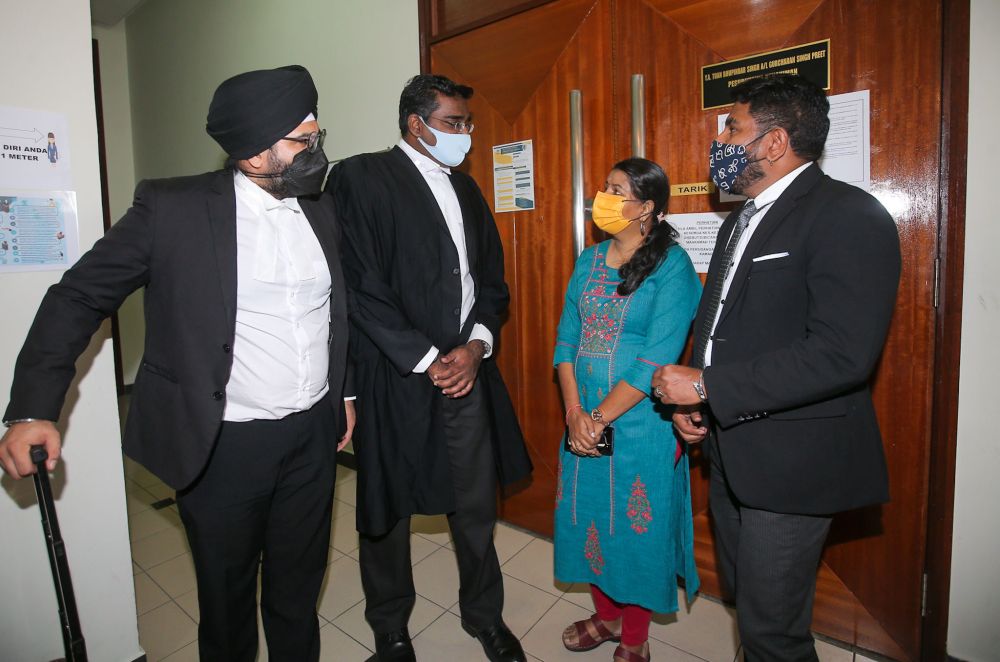 File picture shows M. Indira Gandhi (second from right) speaking to her lawyers at the Ipoh High Court November 15, 2021. — Picture by Farhan Najib