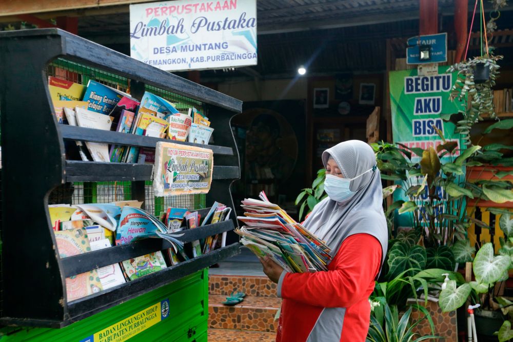 Founder of the waste library (Limbah Pustaka), Raden Roro Hendarti, 48, arranges books on a three-wheeler vehicle at the library in Purbalingga, Indonesia November 2, 2021. u00e2u20acu201d Reuters pic