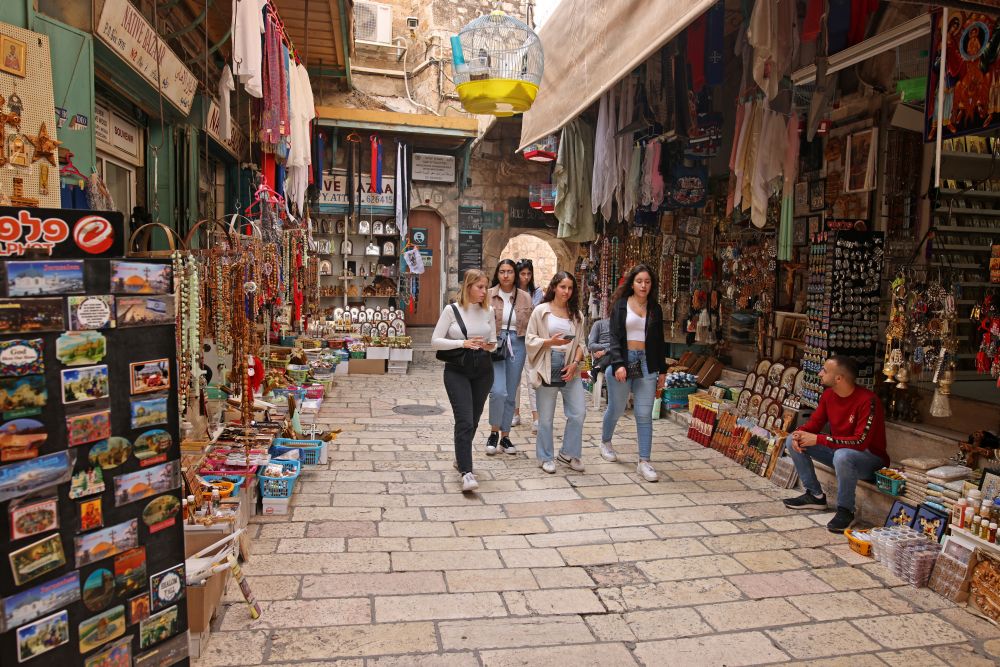 Tourists walk past shops in the Old City of Jerusalem, on November 1, 2021, as Israel reopens to tourists vaccinated against Covid-19. u00e2u20acu201d ETX Studio pic