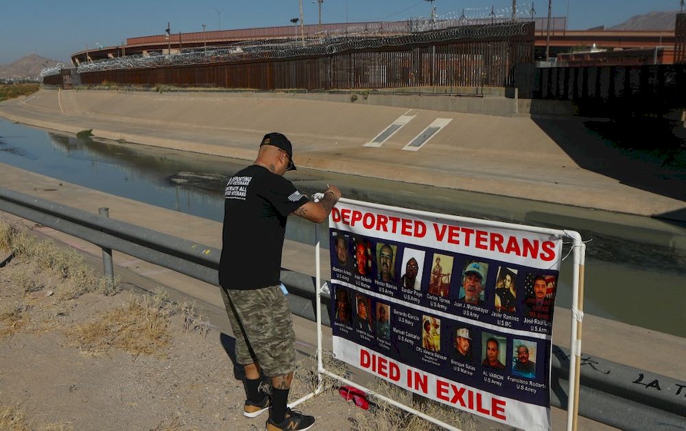 Ivan Ocon, 44, a Mexican veteran of the United States Army deported to Mexico in 2016, ties a banner with pictures of deported veterans who died outside the US in front of the border wall in Ciudad Juarez, Mexico on November 4, 2021. u00e2u20acu201d AFP pic