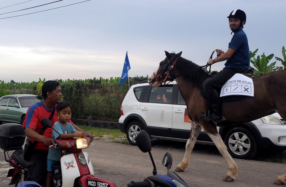Independent candidate in Serkam Datuk Norazlanshah Hazali rides his horse Sandy in Kampung Paya Tanjung, Melaka, November 15, 2021. u00e2u20acu201d Bernama pic 