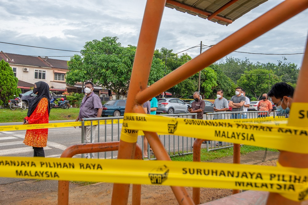 Voters wearing protective masks queue up to cast their votes at the SK Durian Tunggal polling station during the Melaka state election on November 20, 2021. u00e2u20acu2022 Picture by Shafwan Zaidon