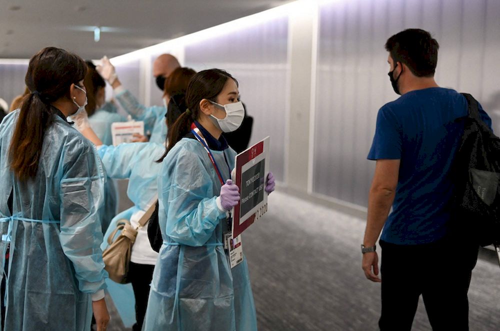 File picture shows airport workers waiting for Olympic athletes and officials arriving on a flight from Doha, at Narita Airport in Chiba Prefecture. u00e2u20acu201d AFP pic