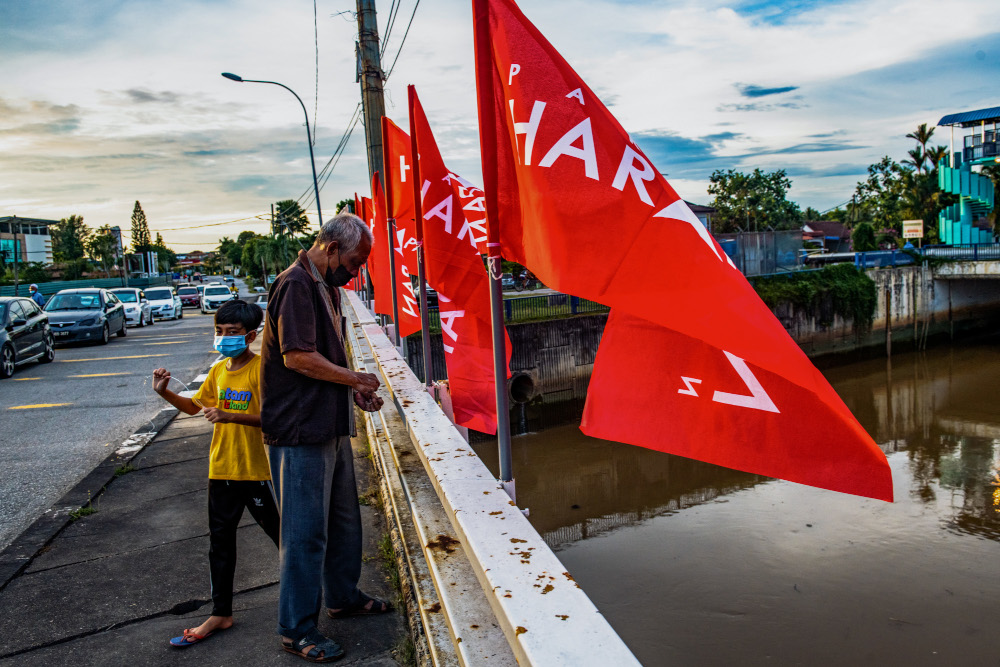 A Pakatan Harapan volunteer putting up PH flags at Jalan Klebang for the Melaka election, November 8, 2021. u00e2u20acu201d Picture by Shafwan Zaidon