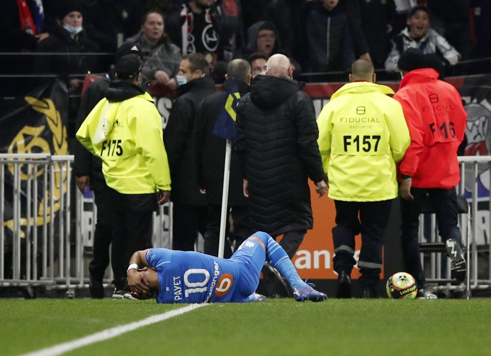 Olympique de Marseille's Dimitri Payet goes down after being hit by a water bottle thrown by a fan at the Groupama Stadium, Lyon November 21, 2021. u00e2u20acu201d Reuters pic