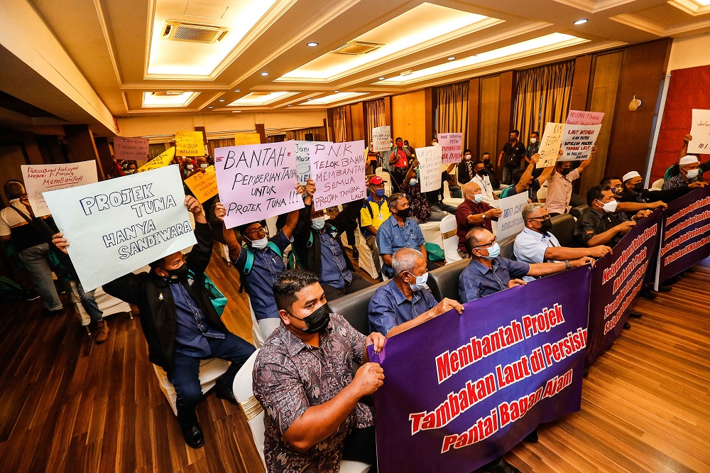 Fishermen hold up placards and banners protesting the Penang South Reclamation project during the Pen Mutiara's annual general meeting in Batu Maung November 25, 2021. u00e2u20acu2022 Picture by Sayuti Zainudin