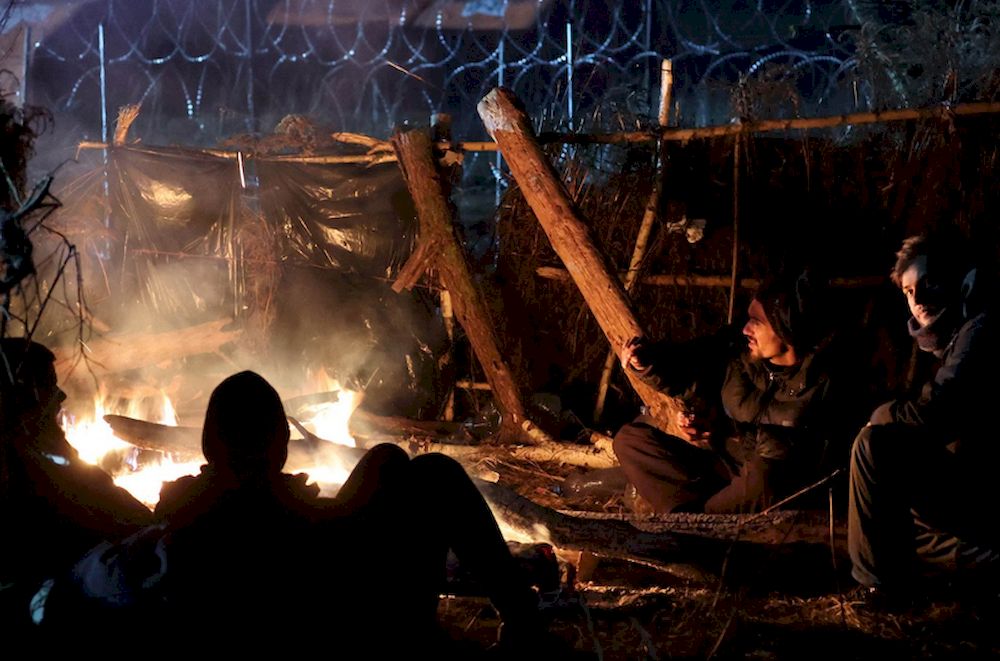 Migrants aiming to cross into Poland warm themselves by a fire on the Belarusian-Polish border in the Grodno region, Belarus, Nov. 16, 2021. u00e2u20acu201d AFP pic