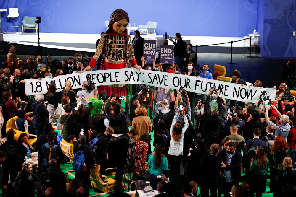 People gather around u00e2u20acu02dcLittle Amalu00e2u20acu2122, a 3.5-metre-tall puppet of a young Syrian refugee girl, during the UN Climate Change Conference (COP26) in Glasgow November 9, 2021. u00e2u20acu201d Reuters pic