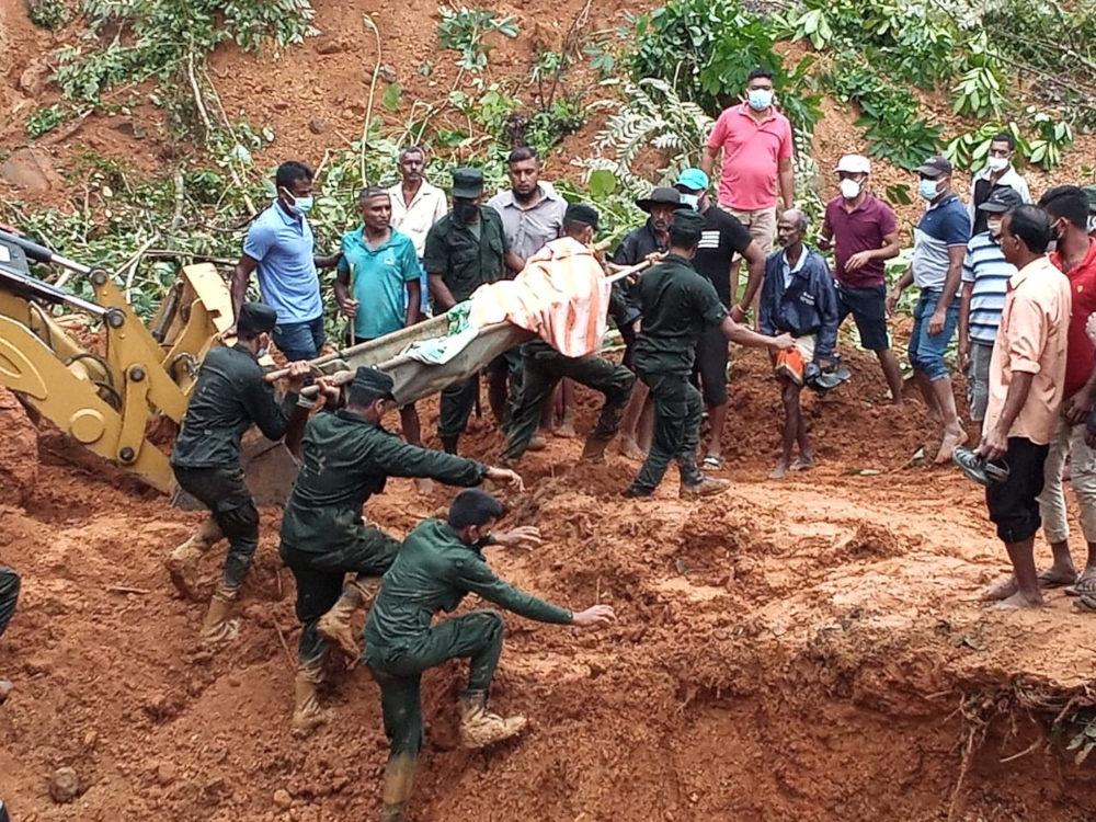 Sri Lanka army soldiers recover a dead body after a residential house collapsed due to a landslide caused by heavy rainfall in Galigamuwa, a divisional secretary area in Sri Lanka November 10, 2021. u00e2u20acu201d Sri Lanka Army Media handout pic via Reutersnn