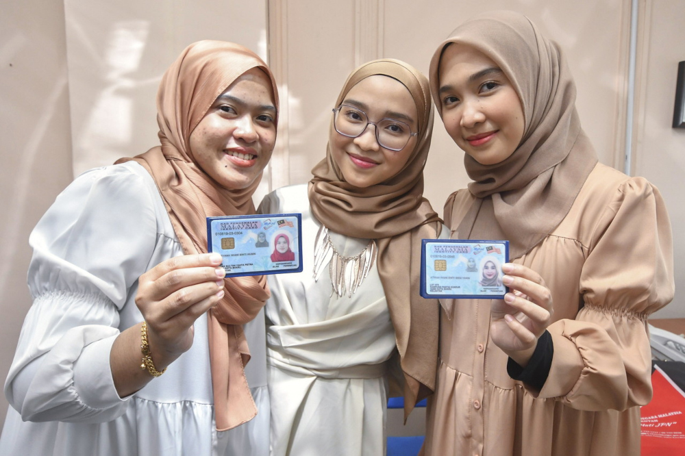 Adryani Iwani Ibeni Yanin, 20, (centre) with her twin Atirah Ibeni Yanin, 20, (right) and Adryana Iwani Husin, 20, when met after the handing over ceremony of the identification documents at Wisma Persekutuan in Kota Baru, November 16, 2021. u00e2u20acu201d Bernama p