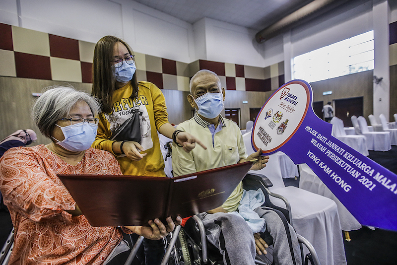 A pleasant surprise for Lee Chuen Hwa (left), her husband Yong Kam Hong (right) and daughter. — Picture by Hari Anggara