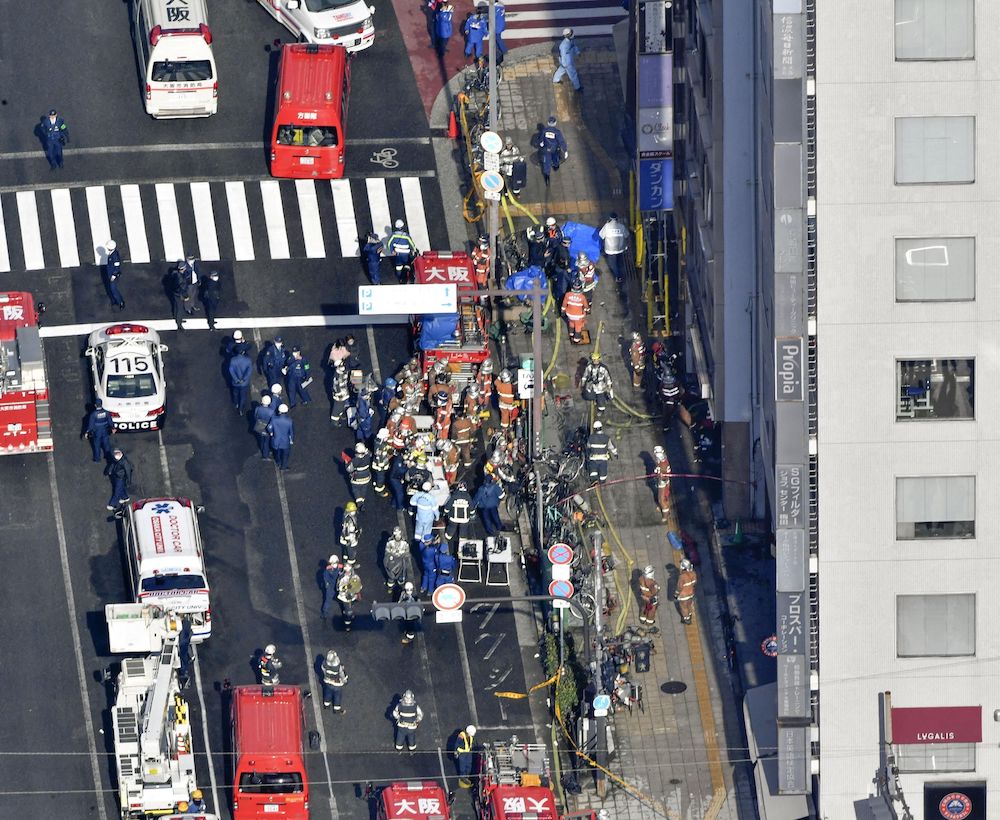 Firetrucks and firefighters are seen in front of a building where a fire broke out in Osaka, western Japan December 17, 2021 in this photo taken by Kyodo. u00e2u20acu201d Kyodo/via Reuters 