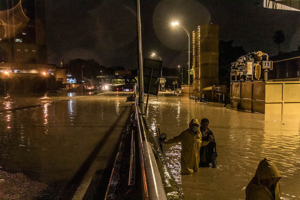 People walk through floodwaters along Jalan Tun Razak in Kuala Lumpur, December 19, 2021. u00e2u20acu201d Picture by Firdaus Latif