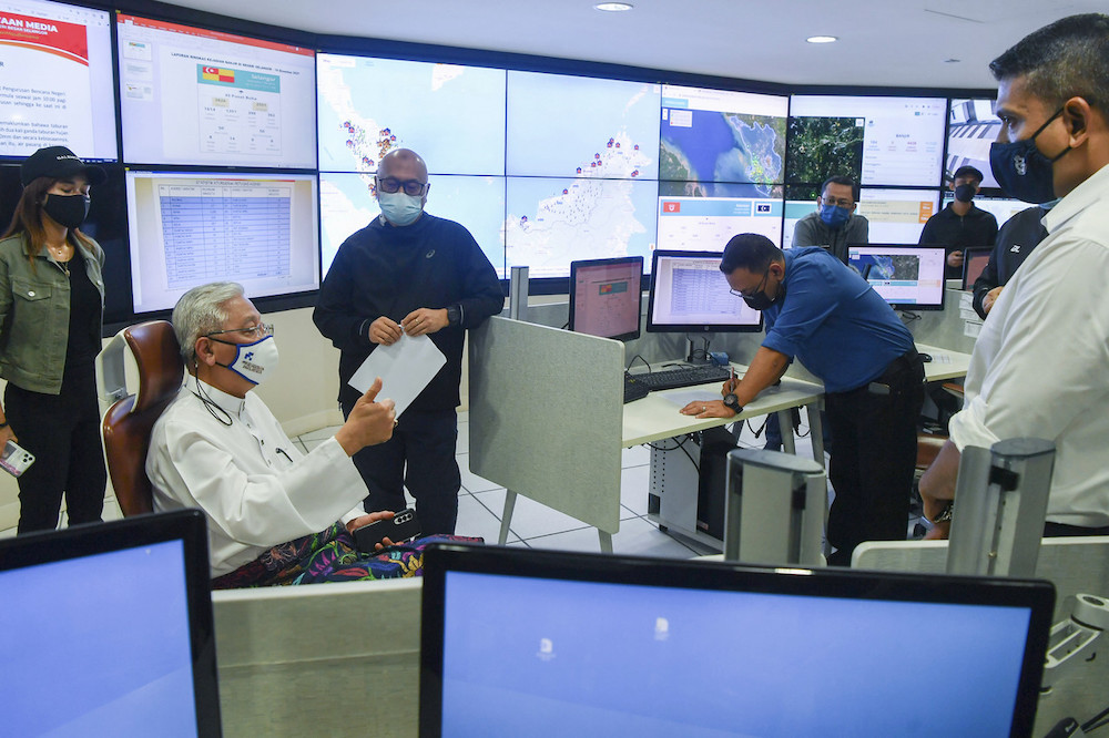 Prime Minister Datuk Seri Ismail Sabri Yaakob being briefed on the countryu00e2u20acu2122s flood situation by Nadma director-general Datuk Aminuddin Hassim at the National Disaster Control Centre in Puchong December 18, 2021. u00e2u20acu201d Bernama pic