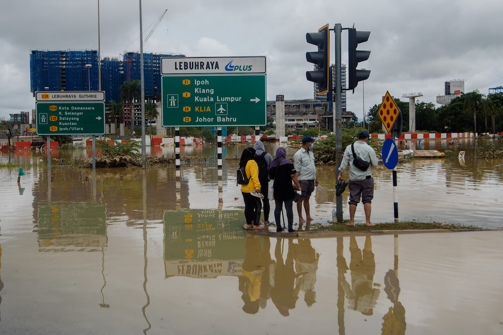 People are stranded in the middle of the road after persistent rainfall caused massive floods in Shah Alam, December 19, 2021. u00e2u20acu2022 Picture by Shafwan Zaidon