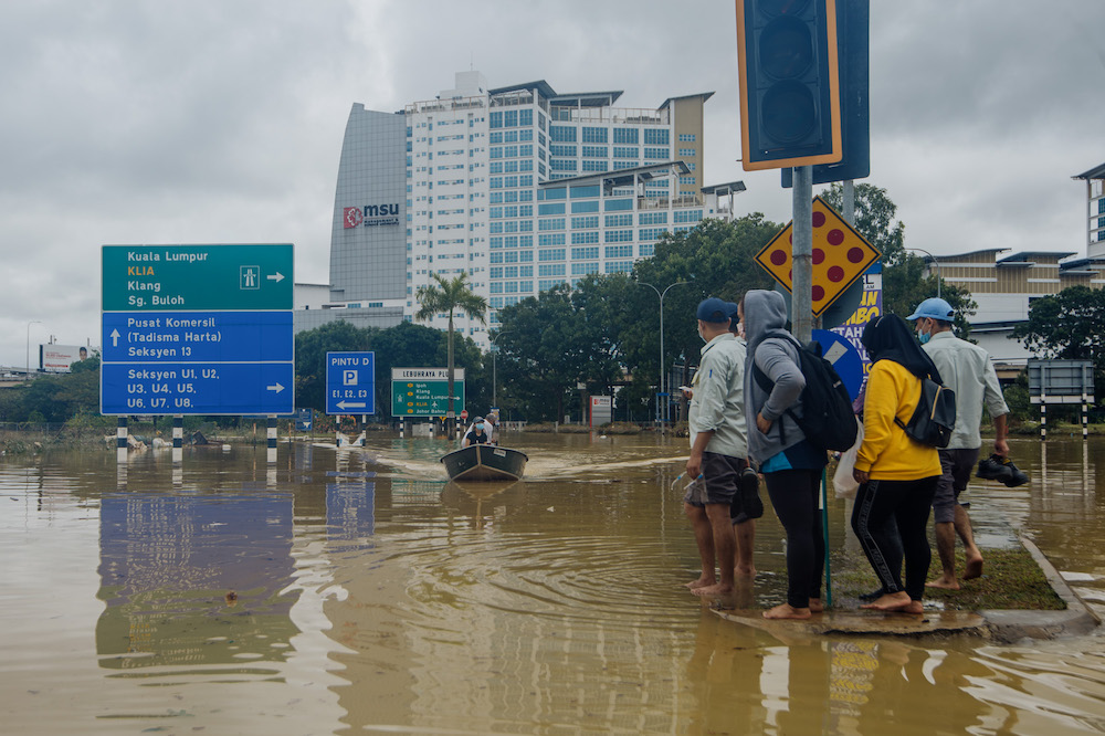 A man uses a boat to rescue people after persistent rainfall caused massive floods in Shah Alam, December 19, 2021. u00e2u20acu2022 Picture by Shafwan Zaidon