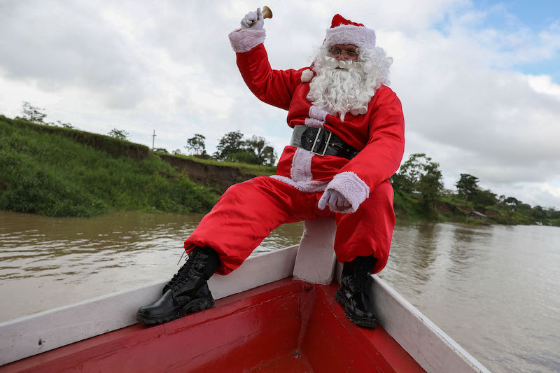 A member of the u00e2u20acu02dcAmigos do Papai Noelu00e2u20acu2122 group, wearing a Santa Claus costume, arrives to Sao Francisco community at Careiro da Varzea, Brazil, a city on the shores of the Amazon River, to give presents to the children, December 18, 2021. u00e2u20acu201d AFP pic