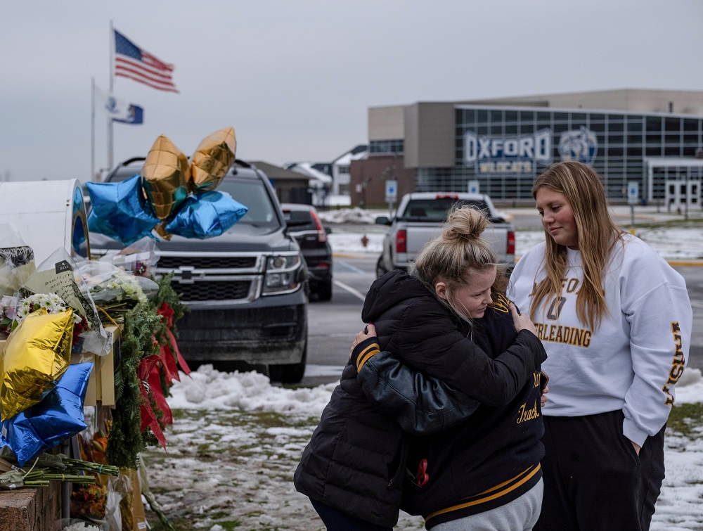 People embrace as they pay their respects at a memorial at Oxford High School, a day after a shooting that left four dead and eight injured, in Oxford, Michigan December 1, 2021. — Reuters pic