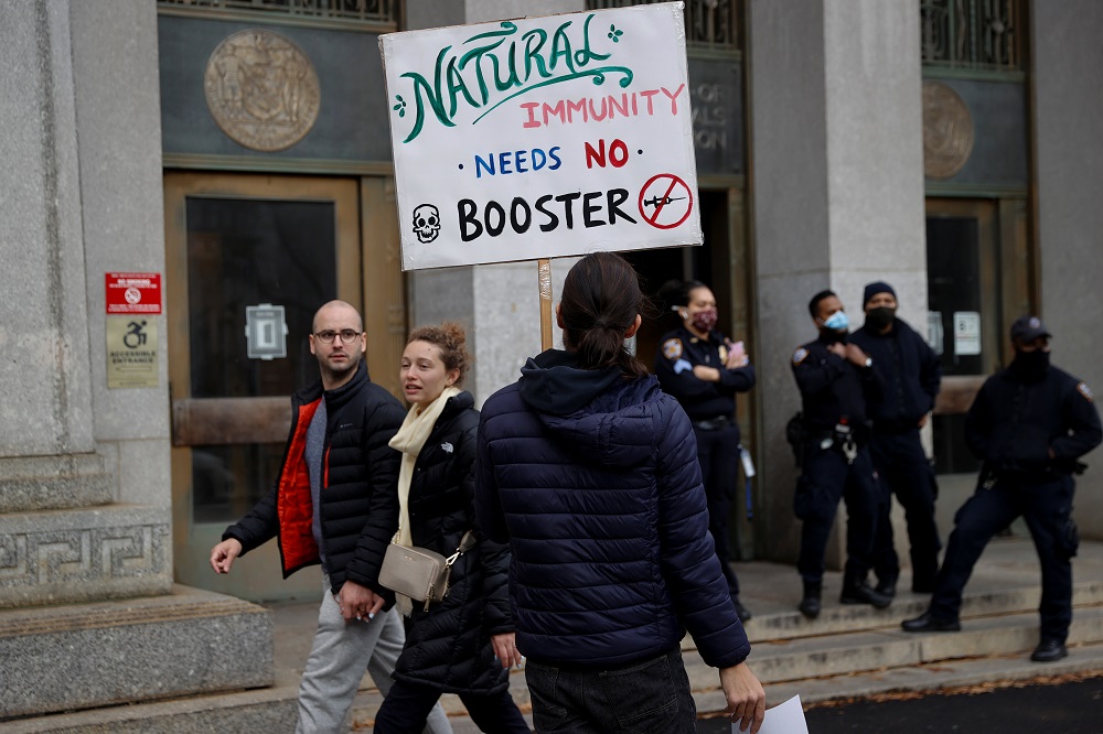 A protestor demonstrates outside the New York City Department of Health offices after New York City Mayor Bill de Blasio announced that all private-sector employers must implement COVID-19 vaccine mandates for their workers, in New York December 6, 2021. 